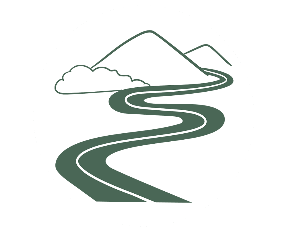 Curvy road winding through mountains and clouds.