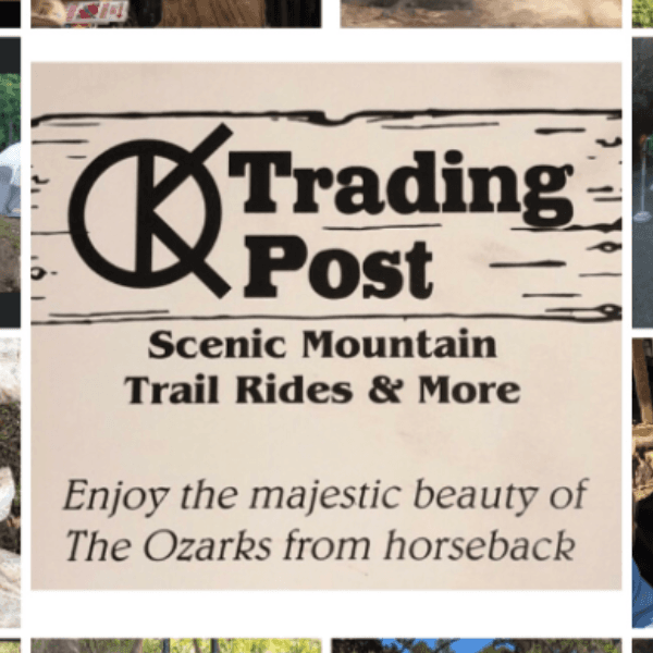 Sign for "K Trading Post" promoting scenic mountain trail rides in the Ozarks.